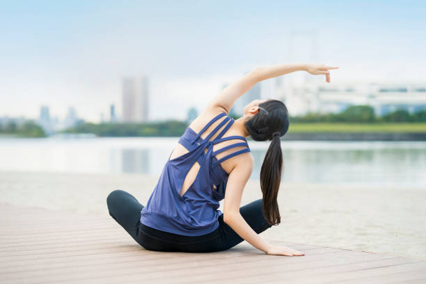 istock Young woman doing yoga on the beach 1286313280