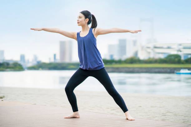 istock Young woman doing yoga on the beach 1286313328