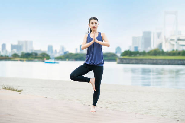 istock Young woman doing yoga on the beach 1286313368