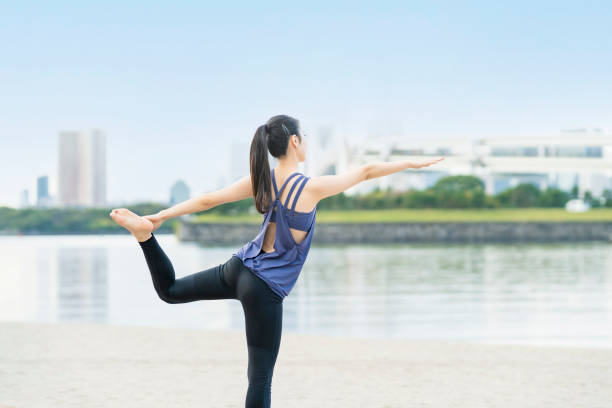 istock Young woman doing yoga on the beach 1286313549