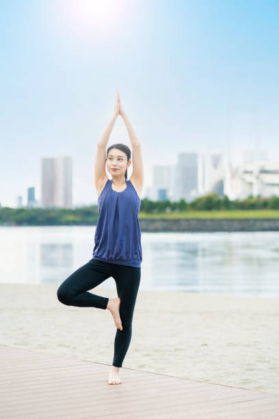 istock Young woman doing yoga on the beach 1286314802