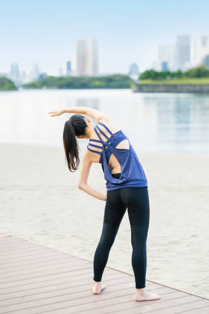 istock Young woman doing yoga on the beach 1286314977