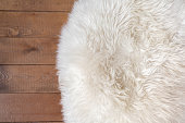 Rough wood floor and white fur rug. New Year or Christmas background. Greeting card