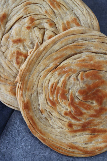 image du paratha de lachha, du blé et de la farine plate, du pain plat indien multicouches, à côté du torchon noir, vue élevée - unleavened bread photos et images de collection