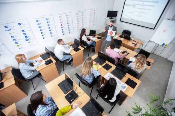 istock Driving instructor holding and showing a STOP sign representation on paper in the classroom 1286319213