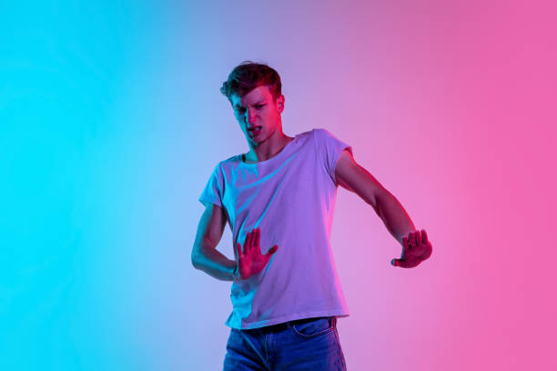 istock Young caucasian man's portrait on gradient blue-pink studio background in neon light 1286319579