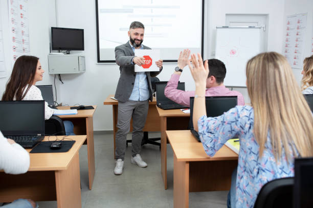 Driving instructor holding an image of a STOP traffic sign