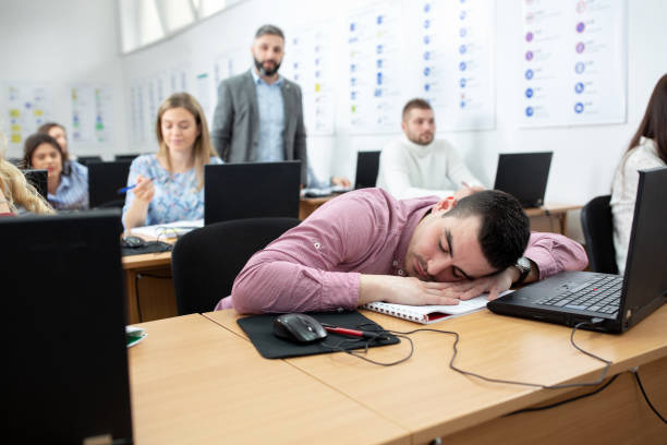 istock Tired student sleeping in the middle of a class 1286321069