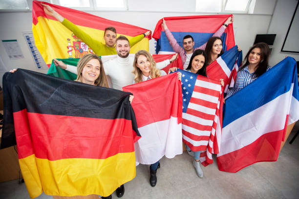 Students holding various flags of different countries in the classroom Students holding various flags of different countries in the classroom, student exchange exchange student stock pictures, royalty-free photos & images