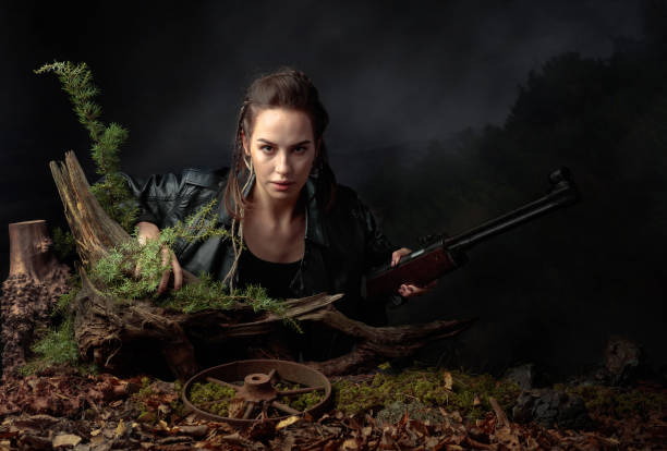 Portrait of a young woman with a rifle. Portrait of a young woman with a rifle. A serious girl in a black leather jacket with a rifle looks menacingly at the camera. Copy space. warrior person photos stock pictures, royalty-free photos & images