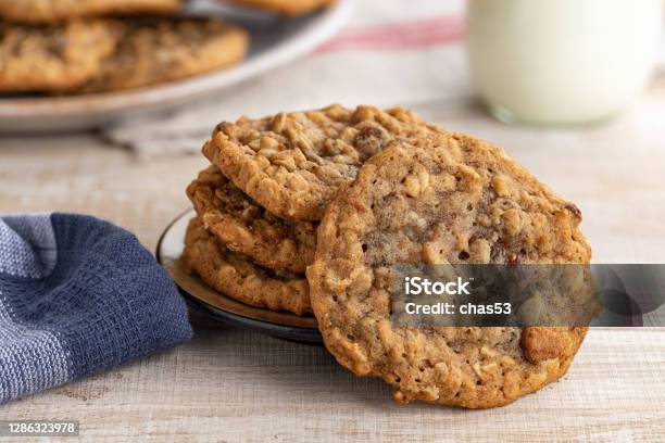 Oatmeal Raisin Cookies And Glass Of Milk Stock Photo - Download Image Now - Oatmeal, Raisin Cookie, Cookie