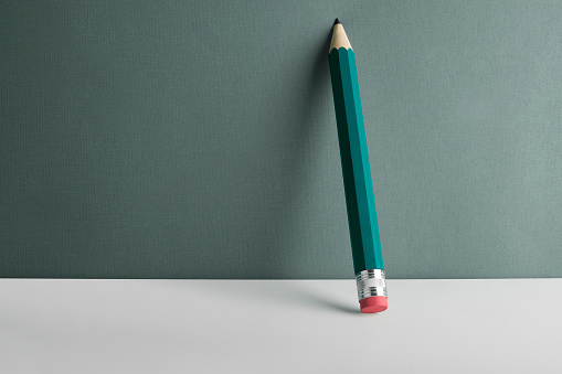 Close-up of a pencil leaning against the wall. 
Copy space for your text.