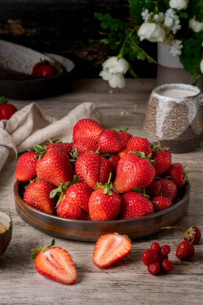 Dark still-life photo with summer strawberry, vertical