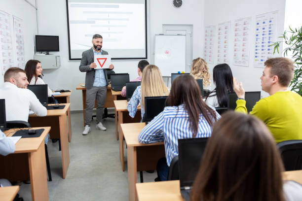 istock Driving instructor showing traffic signs drawn on paper 1286329367