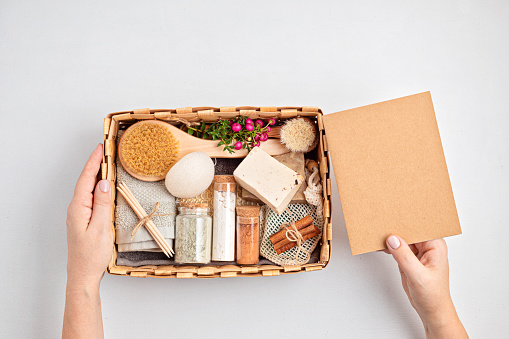 Preparing self care package, seasonal gift box with plastic free zero waste cosmetics products. Personalized eco friendly basket for family and friends for thankgiving, christmas, mothers day