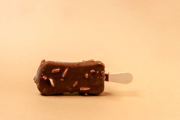 istock Ice cream on a stick in chocolate glaze on a brown background. Copy space. 1286329972