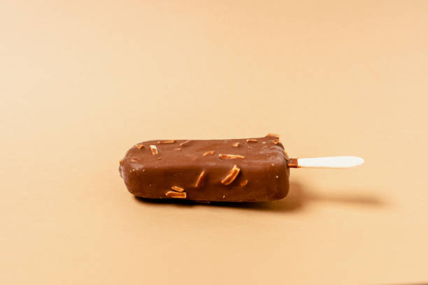 istock Ice cream on a stick in chocolate glaze on a brown background. Copy space. 1286330027