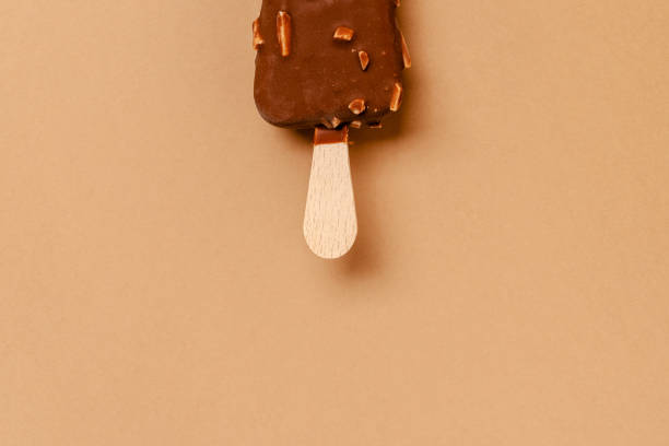 istock Ice cream on a stick in chocolate glaze on a brown background. Copy space. 1286330037