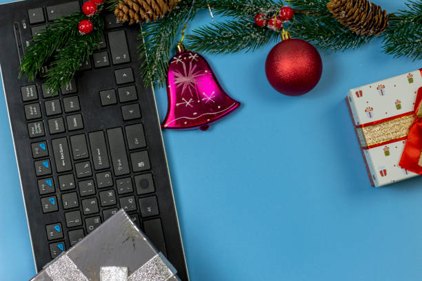istock Decorative Christmas composition. A computer, a gift box, a spruce branch, and Christmas decorations. 1286330692