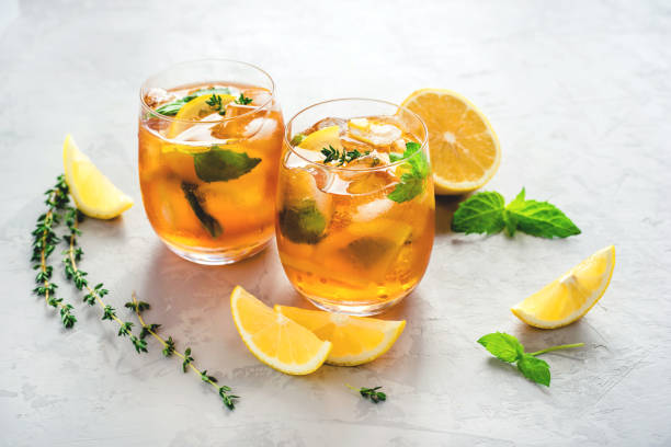 té helado con hielo, menta y limón. - cocktail orange cup juice fotografías e imágenes de stock