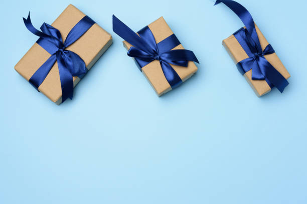 istock rectangular box wrapped in brown paper and tied with a blue silk ribbon with a bow, 1286332896