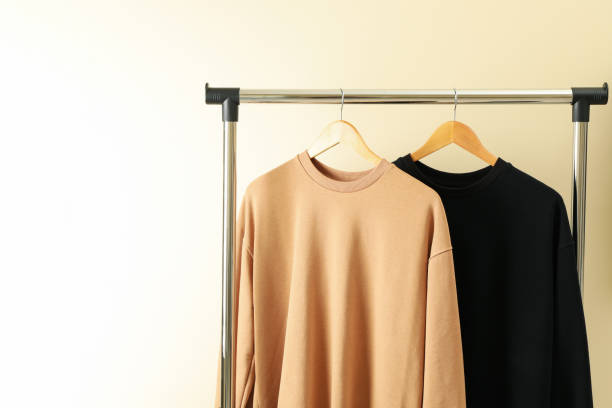istock Hangers with stylish sweatshirts on beige background 1286335652