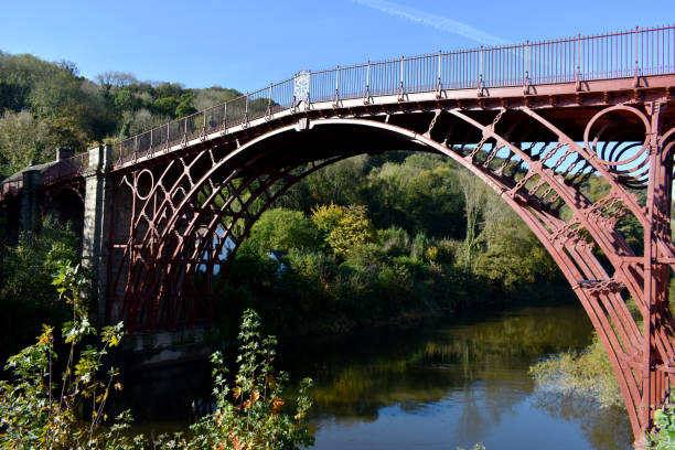 Stunning Ironbridge in Shropshire spanning the River Servern on a sunny day with deep blue sky. The Bridge is painted Red ironbridge shropshire stock pictures, royalty-free photos & images