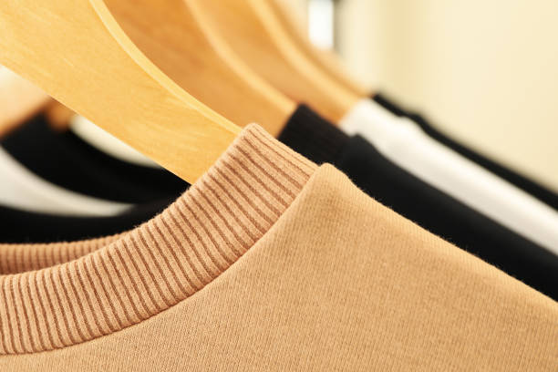 istock Hangers with stylish sweatshirts, close up and space for text 1286335949
