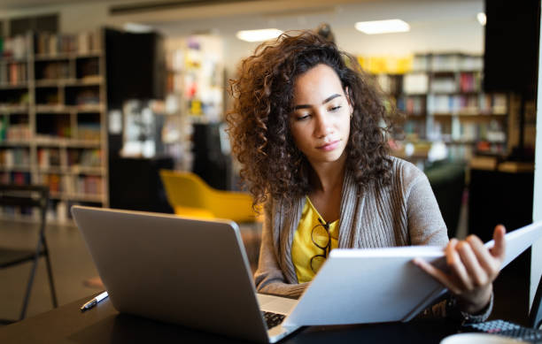 istock Young beautiful student girl working, learning in college library 1286336832