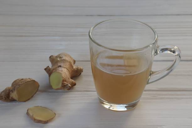 ginger ale in un bicchiere su sfondo bianco in legno - ginger tea root hot drink foto e immagini stock