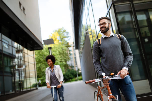 istock Two smiling business people driving electric scooter, bicycle going to work. 1286337108