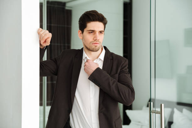 istock Serious young businessman standing in home 1286339483