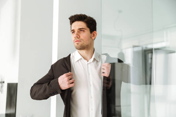 istock Serious young businessman standing in home 1286339587