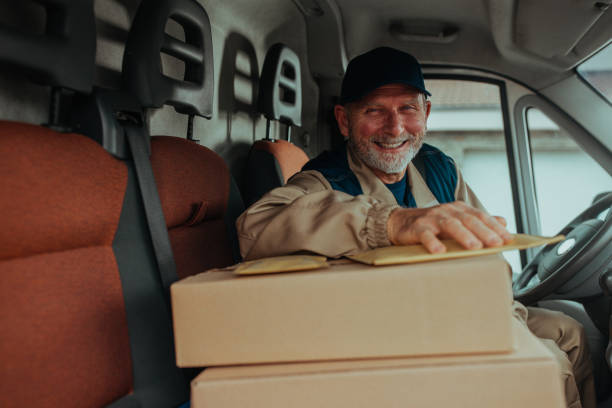 istock Smiling delivery man in his van with boxes on front seat 1286344737