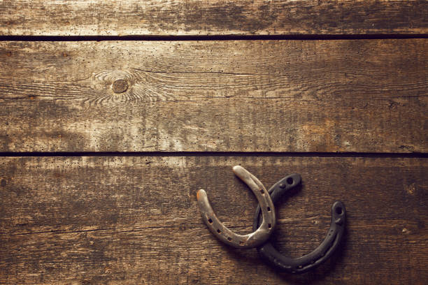 istock Horseshoe with lucky clover on a wooden background 1286344743