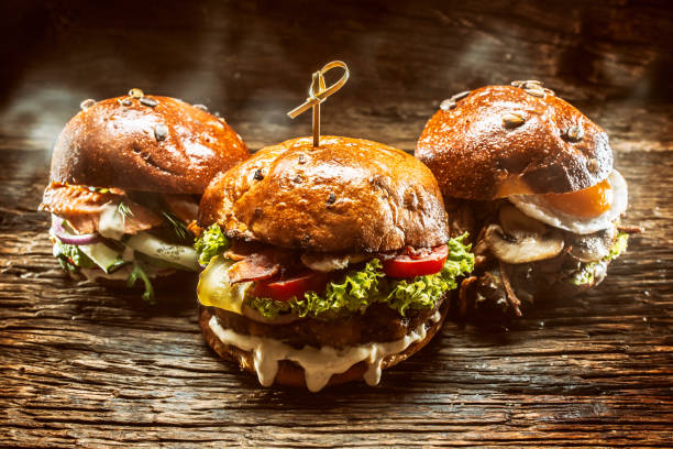 istock Front view on three large, beef salmon and kebab burgers stuffed with fresh vegetable salad and dressing 1286345895