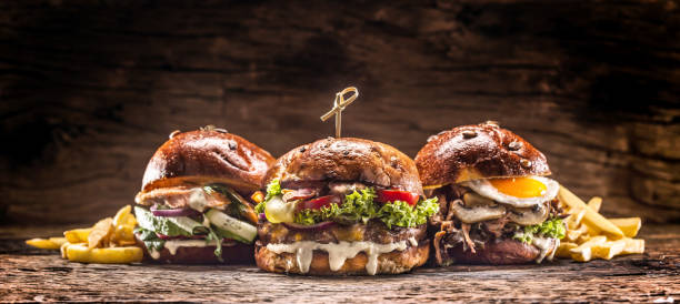 istock Front view on three large, beef salmon and kebab burgers stuffed with fresh vegetable salad and dressing 1286345940