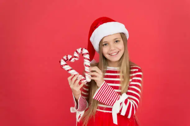 sweet and lovely. christmas shopping time. happy new year celebration. festive party in red color. sweet childhood happiness. small girl have fun. santa elf kid candycane. xmas holiday decoration.