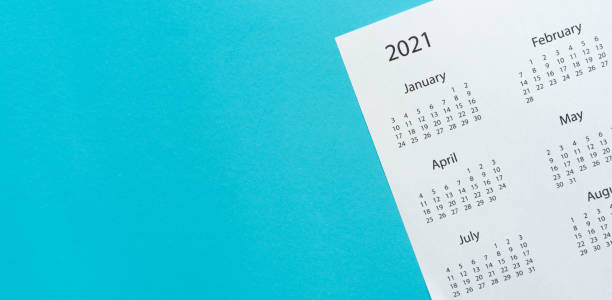close up top view on white calendar 2021 schedule on blue color background to make appointment meeting or manage timetable each day for design planning work and life concept