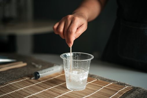 close up of young women hand stirring baking soda with a cup of water