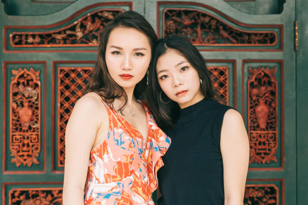 Two serious looking young asian women. They're looking at the camera.