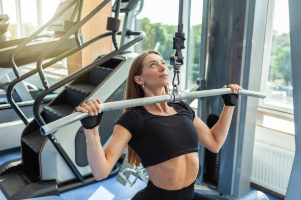 istock Beautiful young fit woman working out on a pull down lat machine at the gym 1286351716
