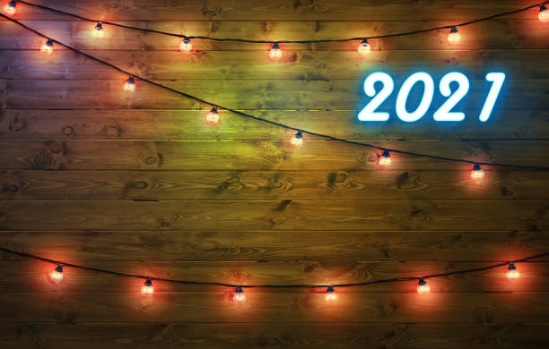 2021 felice anno di nuovo sfondo. numeri al neon 2021 e ghirlande con luci su sfondo in legno. copyspace. - 6639 foto e immagini stock