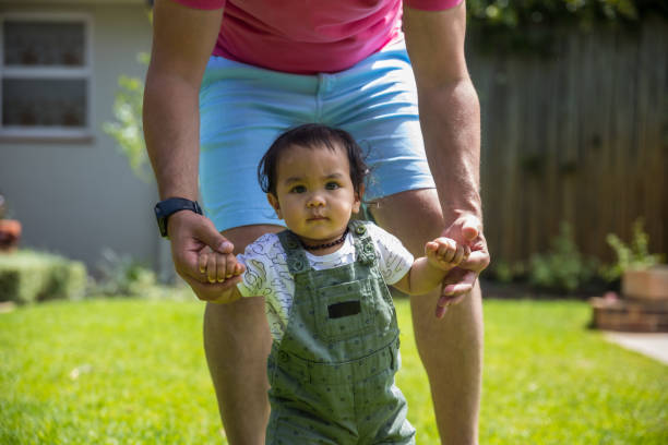 istock Father helping his daughter walk 1286355958