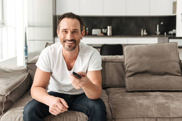 istock Smiling mature man sitting on a sofa 1286355965