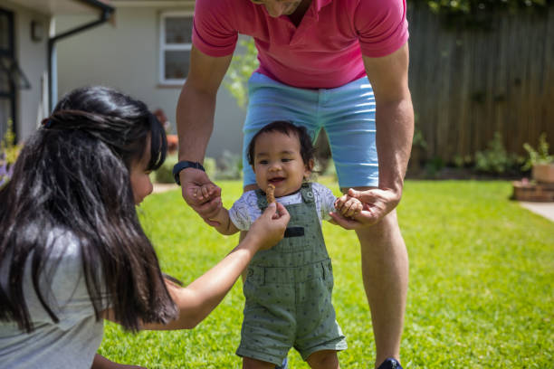 istock Father helping his daughter walk 1286356072