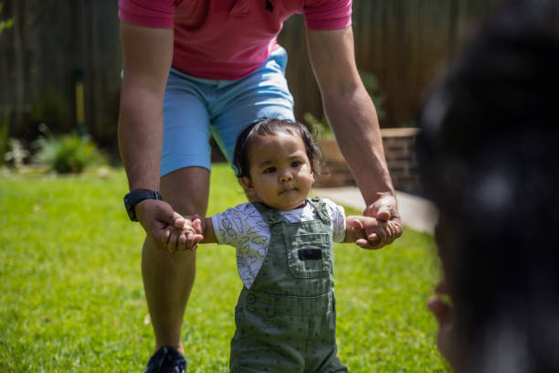istock Father helping his daughter walk 1286356118