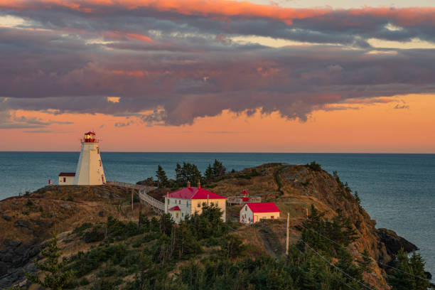 Swallowtail lighthouse at sunset swallowtail lighthouse with beautiful sunset colors overlooking the bay of fundy new brunswick canada photos stock pictures, royalty-free photos & images
