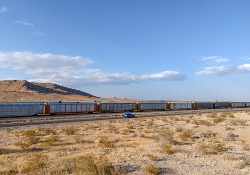 Freeway and cargo train traffic on desert landscape