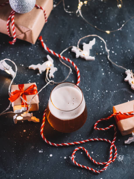 istock Christmas table with a glass of beer, gift boxes, garlands 1286357370